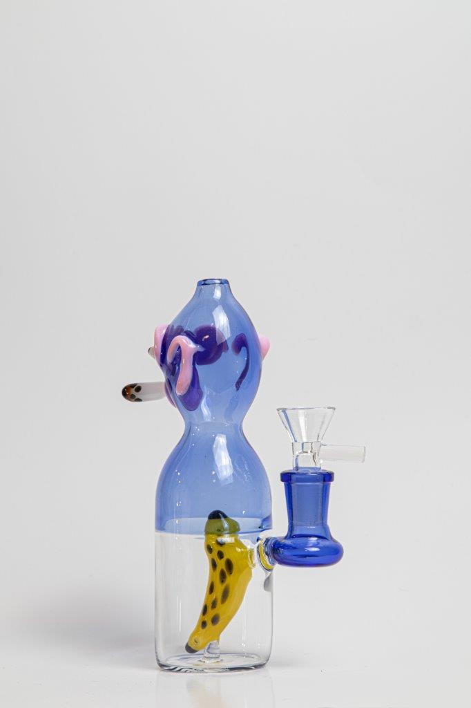 7 inch Smoking Monkey Water Pipe – a whimsical addition to your weed and dab collection in water bong style glass. For sale now, this unique water bottle-shaped piece includes a 14MM male bowl and a banana-shaped bent down stem. The integrated percolator ensures a smooth smoking experience, preventing water splashback, cooling the smoke down, and providing extra filtration