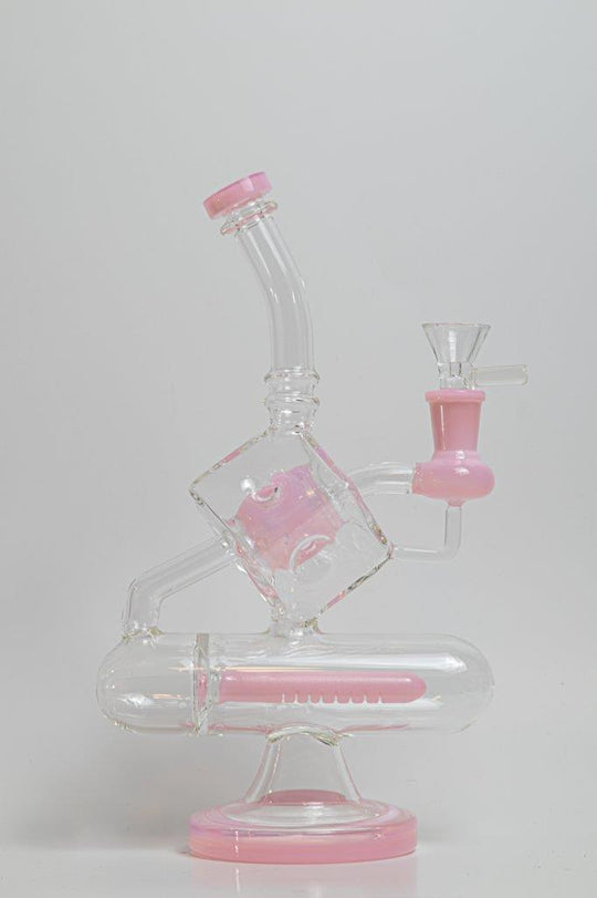 Pink Incline Water Pipe – an 10-inch cube-designed wonder perfect for weed and dabs. Now available for sale, this distinctive piece includes a 14MM male bowl for weed, a bent-down stem, and a bubble percolator, providing a unique smoking experience with efficient filtration. The percolator prevents water from splashing back into your mouth, cools the smoke down