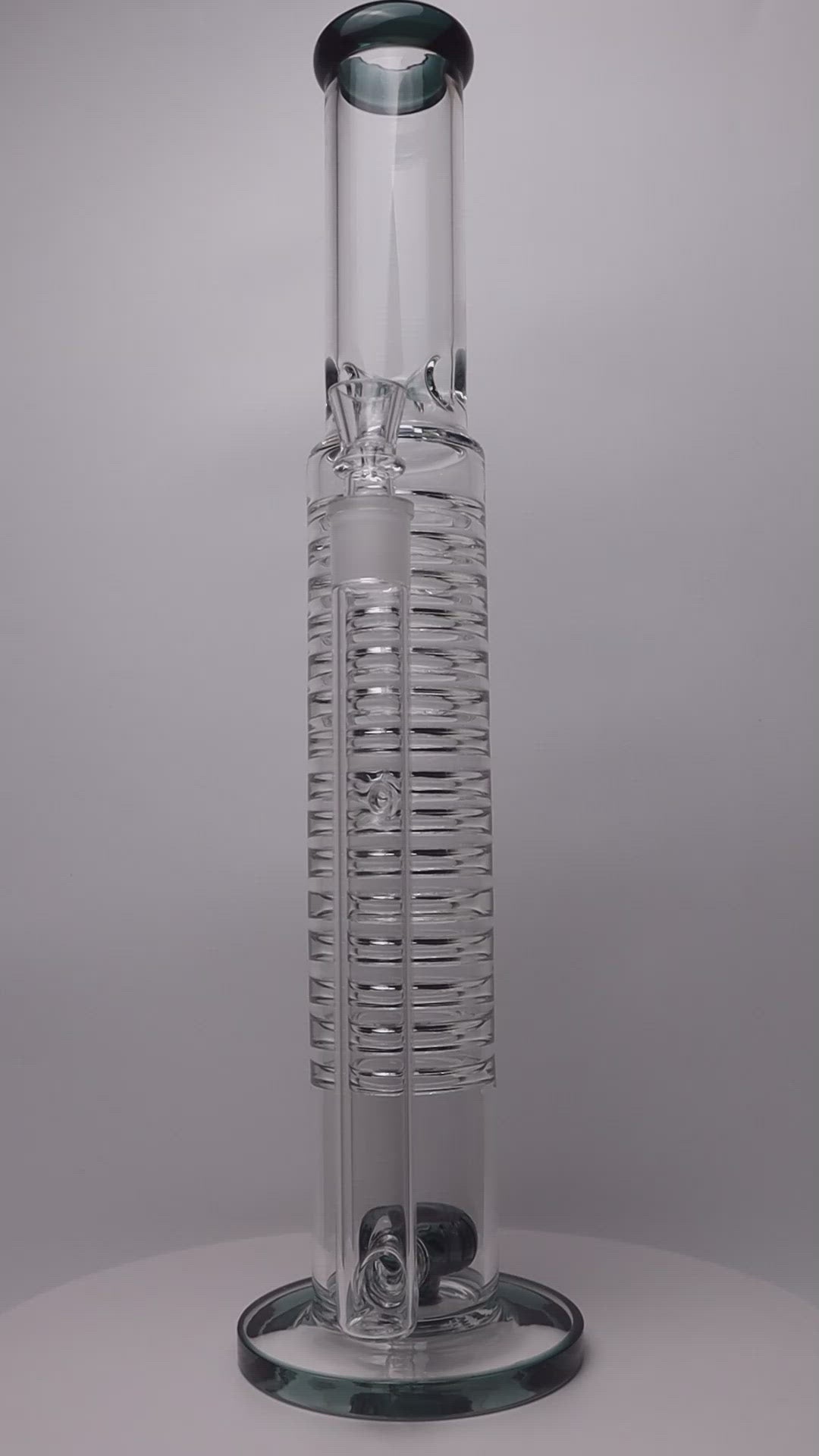 18-inch Slinky Water Pipe – a straight glass marvel designed for weed and dabs in water bong style glass. Now available for sale, this unique piece includes a 14MM male bowl and a bent bubbler down stem. The integrated percolator offers a smooth smoking experience, preventing water splashback, cooling the smoke down, and providing extra filtration